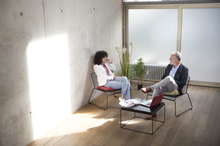Two people in conversation during a coaching session in a bright loft